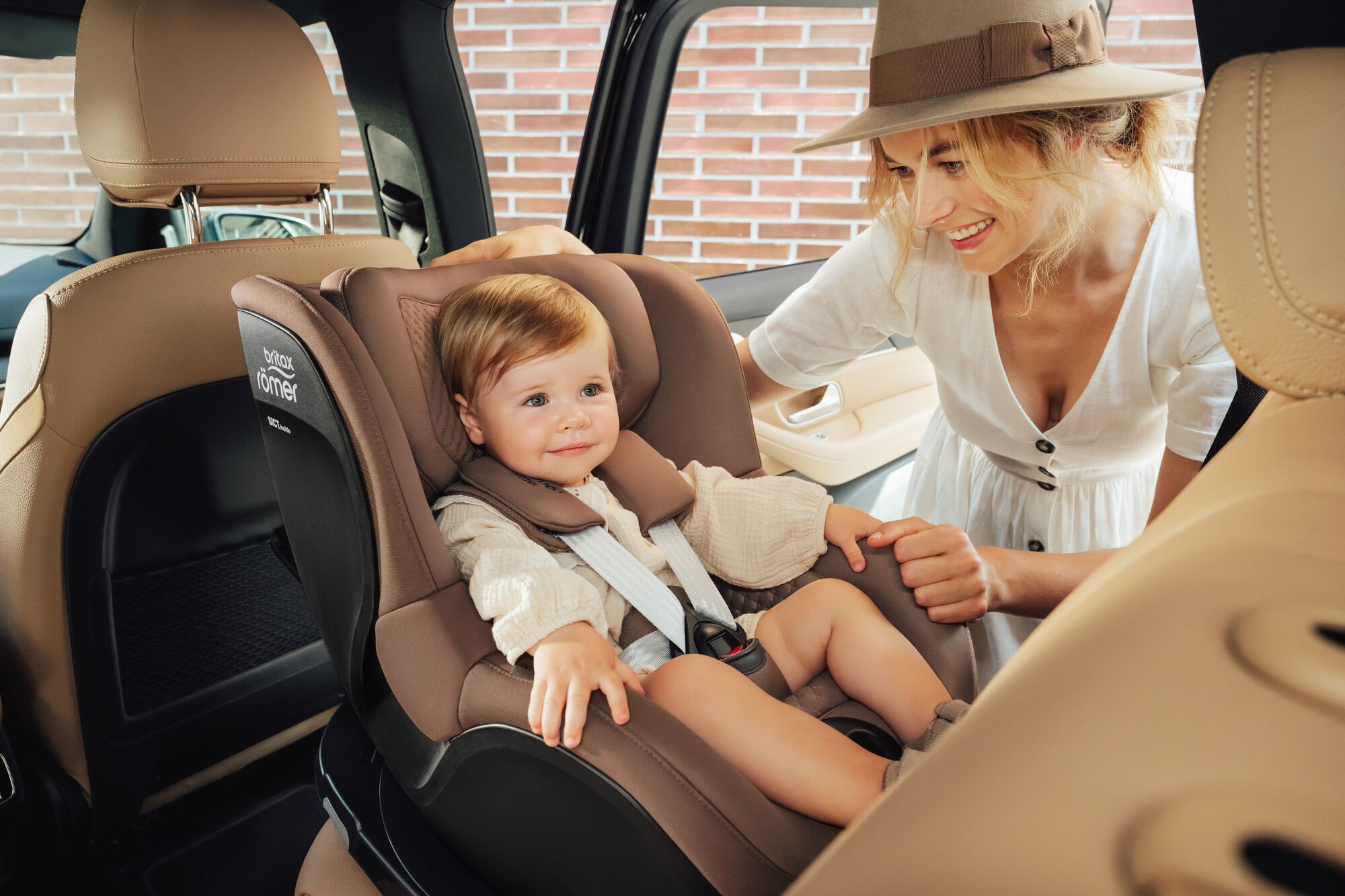 Bambino seduto in un seggiolino auto DUALFIX 5Z toddler car seat, con sua madre accanto.